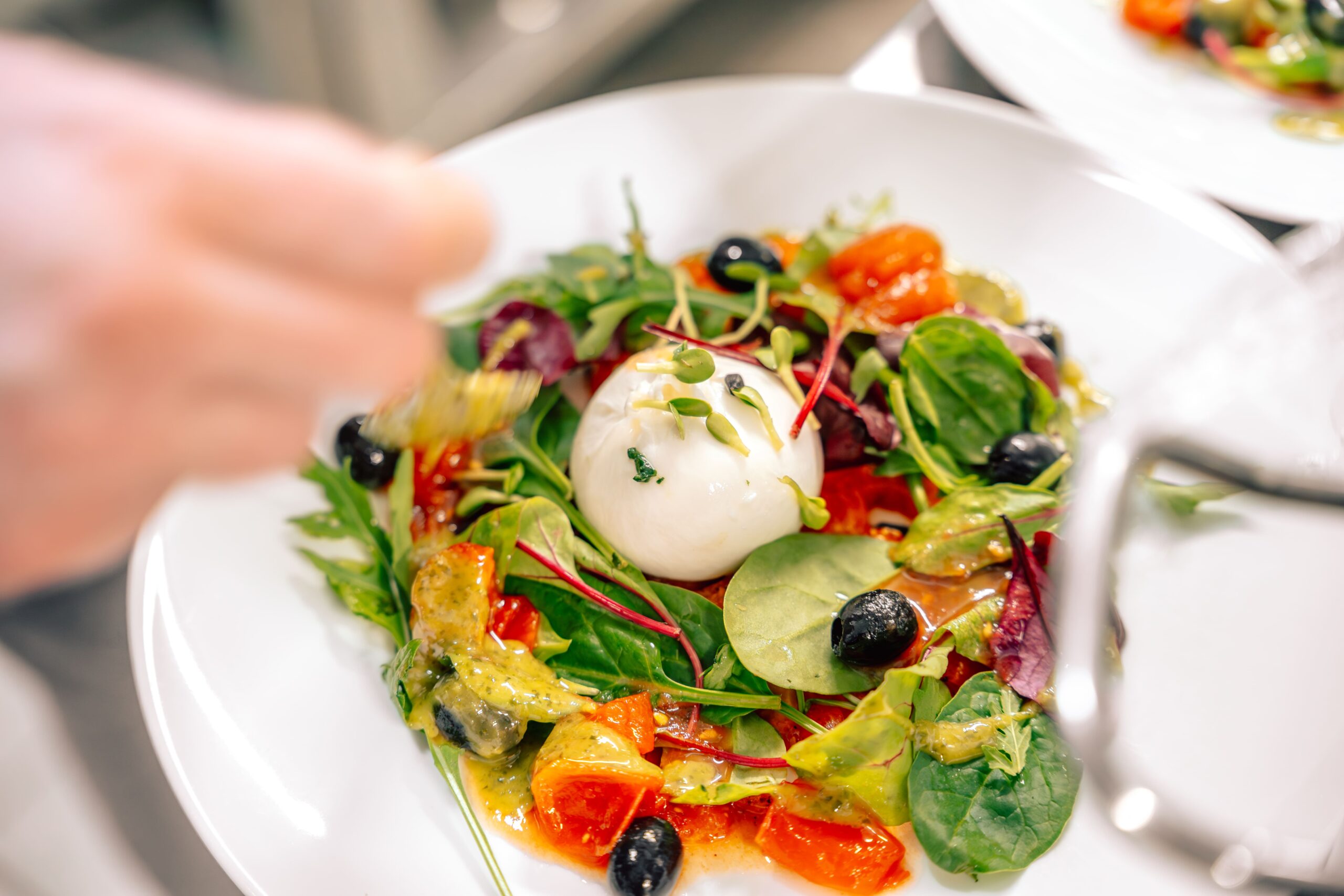 Detailaufnahme der Ochsenherztomate mit Buratta und Basilikum-Limetten-Vinaigrette